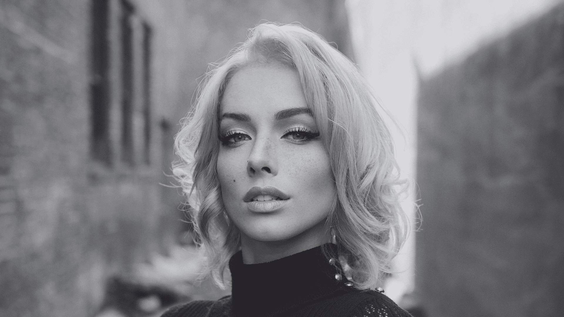 Short-haired woman in alley, black and white portrait.